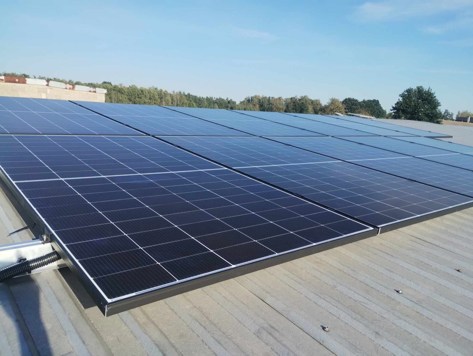 Panele fotowoltaiczne na dachu hali produkcyjnej